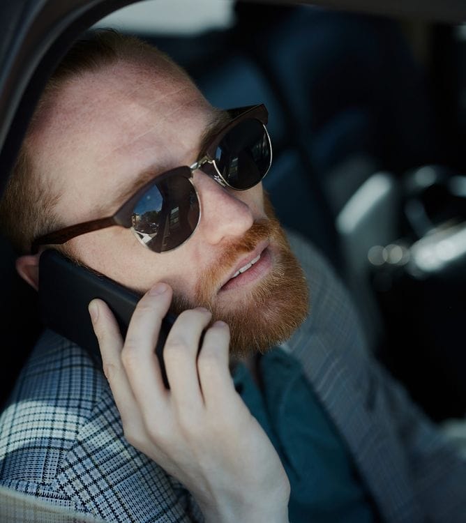 Client on the phone inside luxury chauffeur vehicle