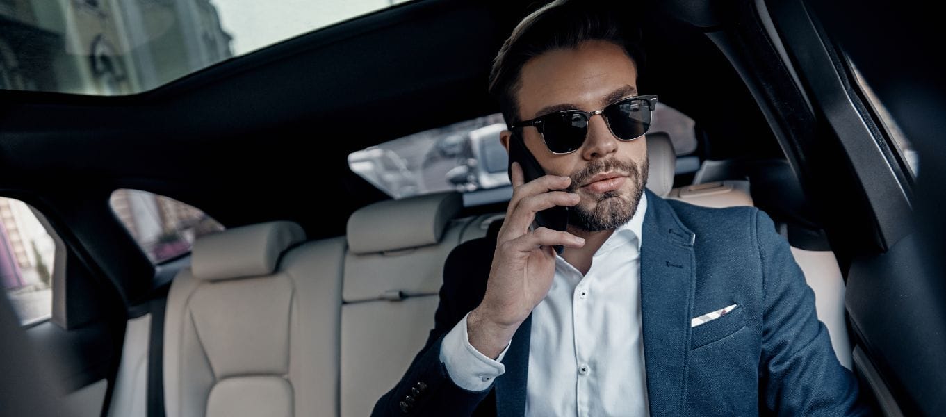 Client taking a phone call inside a luxury chauffeur vehicle