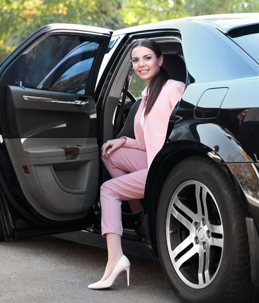 A client posing while sat in a luxury chauffeur vehicle