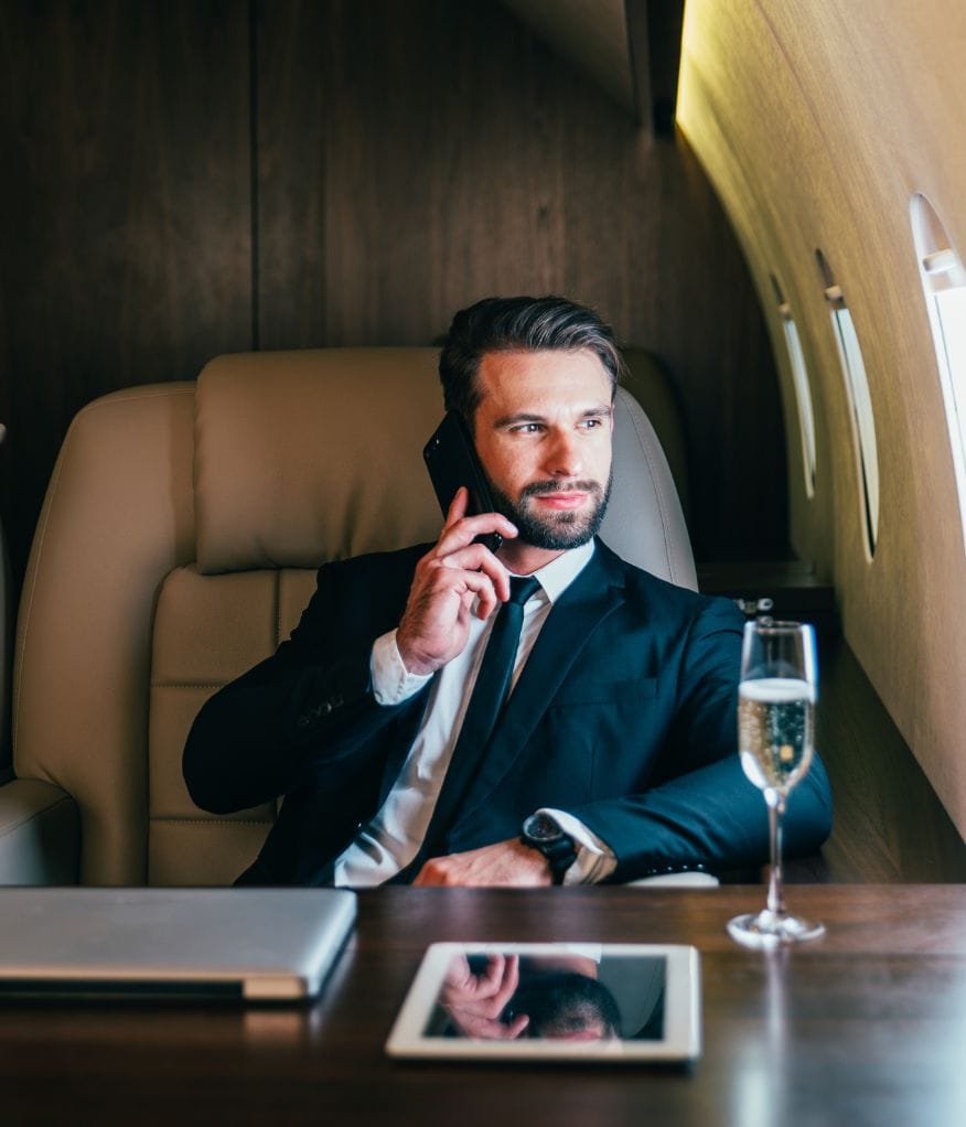 A man taking a phone call on a private jet