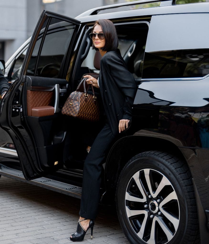 A corporate client stepping out of a luxury chauffeur vehicle