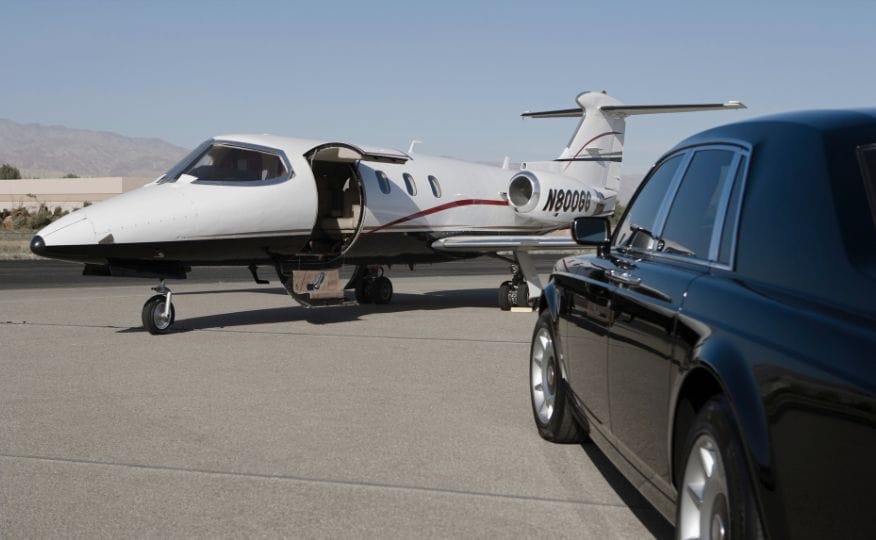 A private jet alongside a luxury chauffeur vehicle