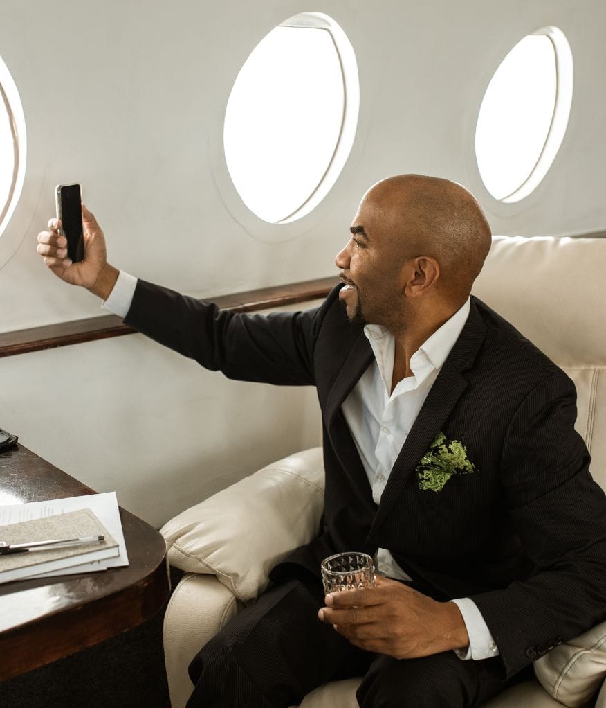 A man taking a photo on a private jet