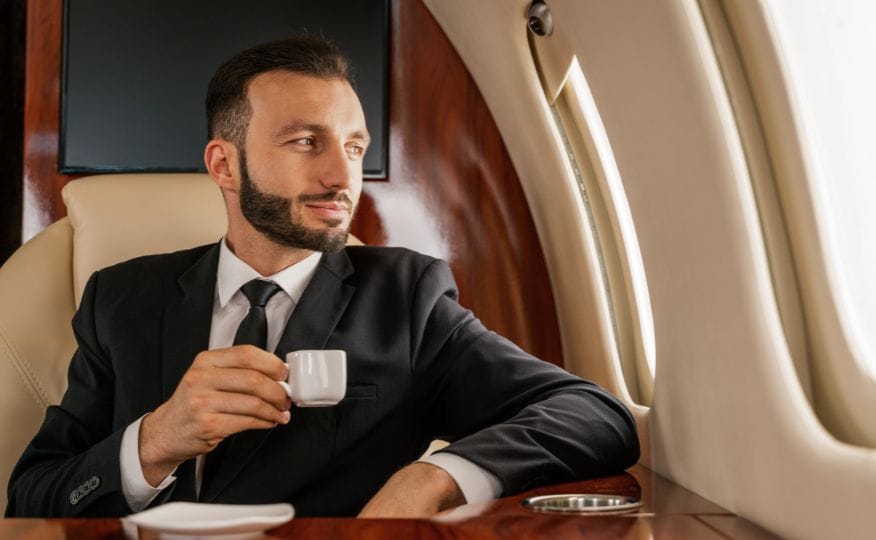 A man looking out the window of a private jet